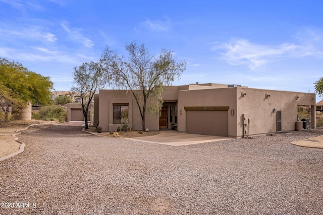 pueblo revival-style home featuring a garage