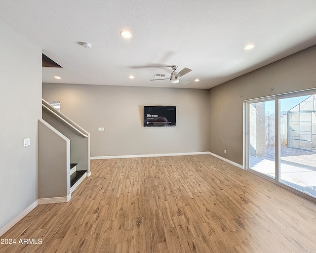 unfurnished living room with ceiling fan and light wood-type flooring