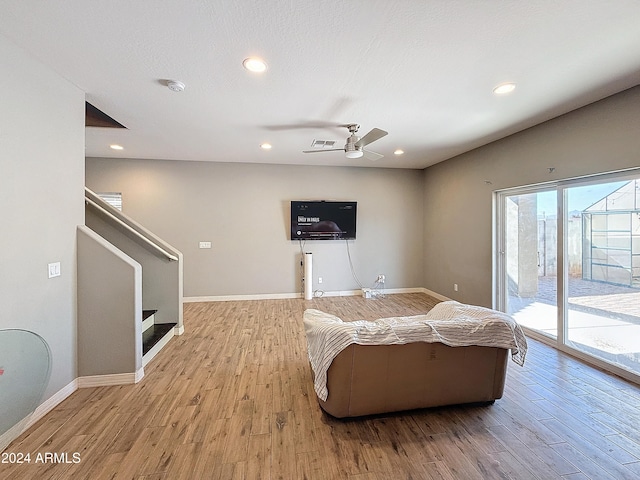 living room with ceiling fan and light wood-type flooring