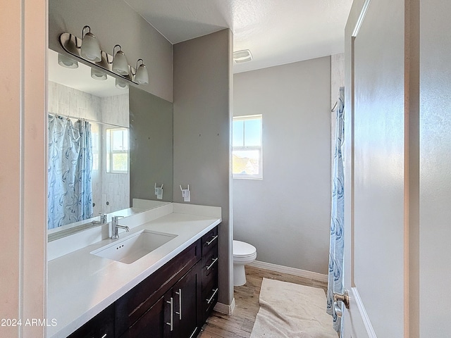 bathroom with vanity, hardwood / wood-style flooring, toilet, and plenty of natural light