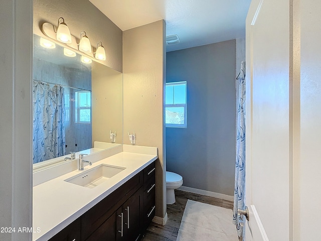 bathroom with hardwood / wood-style floors, vanity, a shower with shower curtain, and toilet