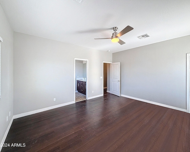 unfurnished bedroom featuring ceiling fan, dark wood-type flooring, and ensuite bath