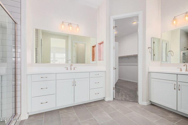 bathroom featuring vanity, a shower with shower door, and tile patterned flooring