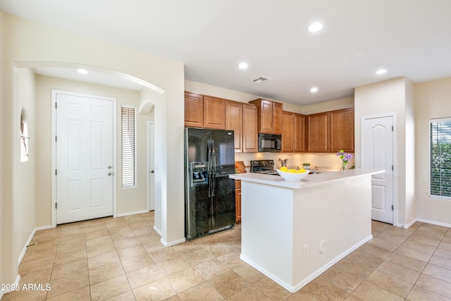 kitchen featuring light tile patterned floors, black appliances, and a kitchen island