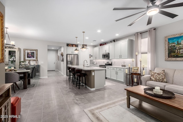 tiled living room featuring ceiling fan and sink