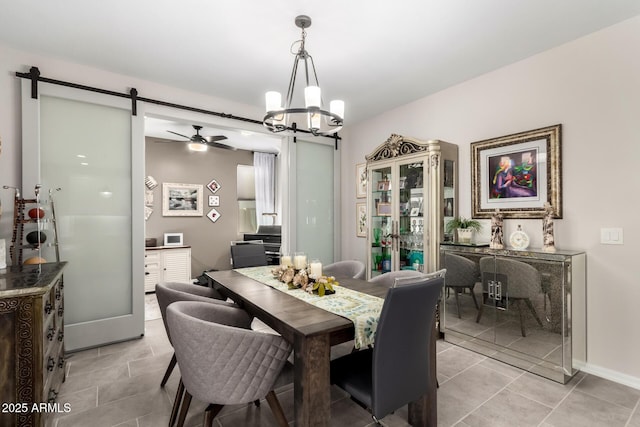 dining room featuring a barn door and ceiling fan with notable chandelier