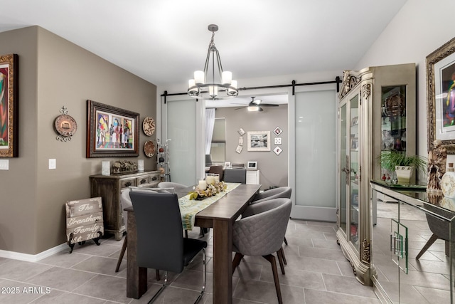 tiled dining area with a barn door and ceiling fan with notable chandelier