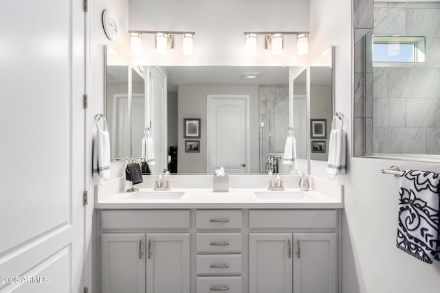 bathroom featuring a shower with shower door and vanity