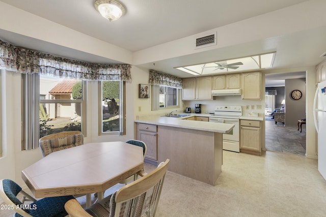 kitchen featuring ceiling fan, kitchen peninsula, sink, white appliances, and light brown cabinets