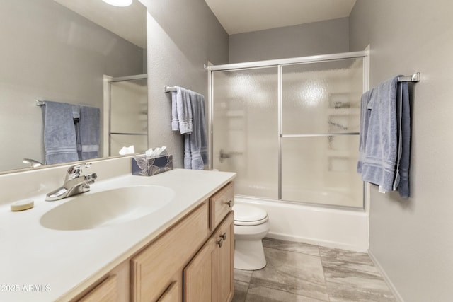 full bathroom featuring toilet, vanity, and shower / bath combination with glass door