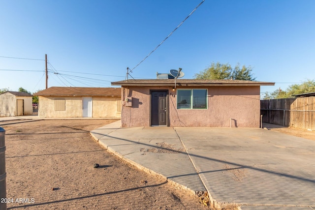 view of front facade with a storage unit and a patio