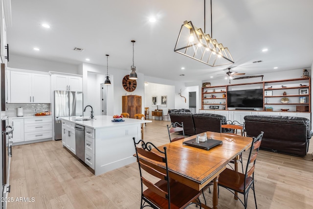 dining space with recessed lighting, a ceiling fan, and light wood-style floors