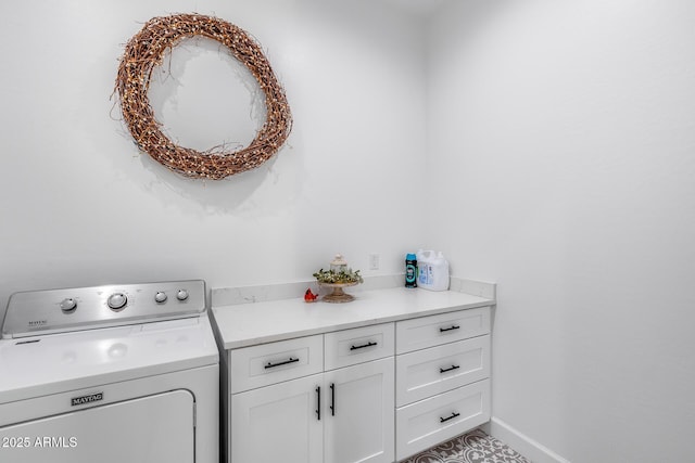 washroom with cabinet space, washer / dryer, and baseboards