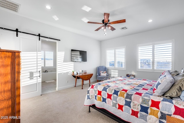 bedroom featuring a barn door, recessed lighting, visible vents, and light colored carpet