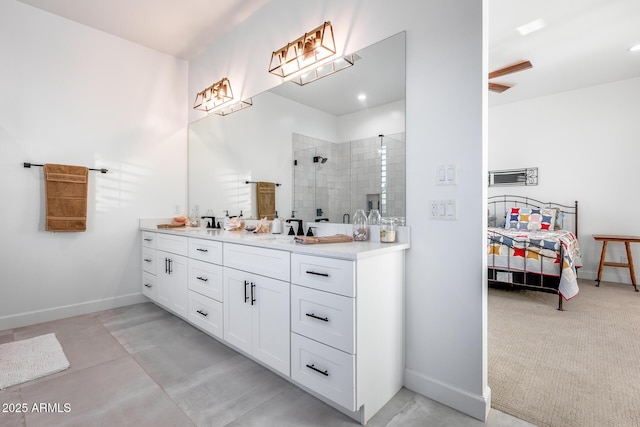 full bathroom featuring double vanity, baseboards, a tile shower, and a sink