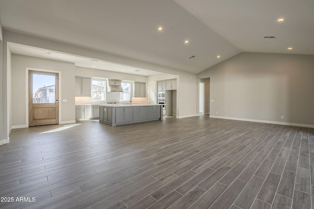 10972 N Hershey St, Surprise, AZ 85388 - unfurnished living room with baseboards, visible vents, dark wood finished floors, vaulted ceiling, and recessed lighting