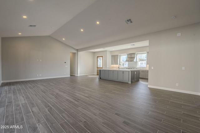 10972 N Hershey St, Surprise, AZ 85388 - unfurnished living room featuring lofted ceiling, baseboards, visible vents, and dark wood finished floors