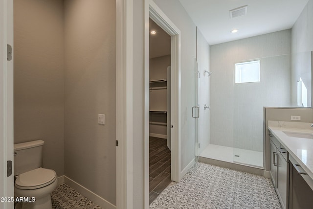 10972 N Hershey St, Surprise, AZ 85388 - bathroom with a stall shower, visible vents, toilet, a walk in closet, and vanity