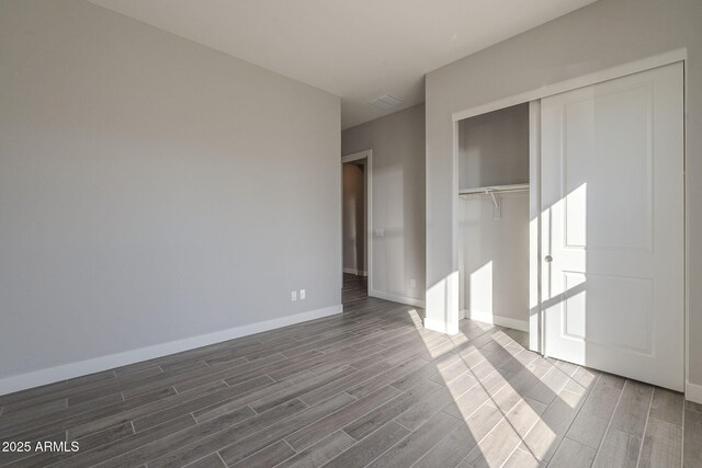 10972 N Hershey St, Surprise, AZ 85388 - unfurnished bedroom with wood tiled floor, a closet, and baseboards