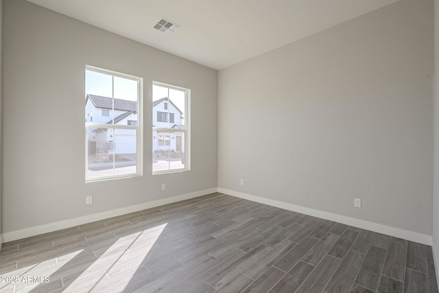 10972 N Hershey St, Surprise, AZ 85388 - spare room featuring wood finish floors, visible vents, and baseboards