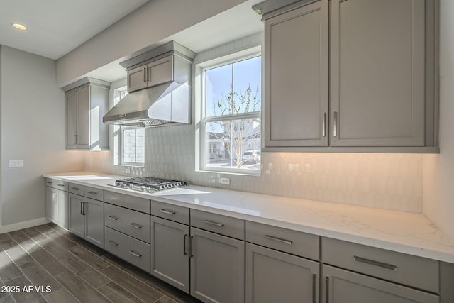 10972 N Hershey St, Surprise, AZ 85388 - kitchen with under cabinet range hood, stainless steel gas cooktop, wood finish floors, gray cabinets, and decorative backsplash