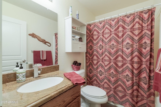 bathroom with walk in shower, vanity, and toilet