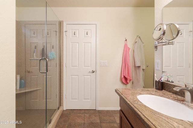 bathroom with a shower with door, vanity, and tile patterned flooring