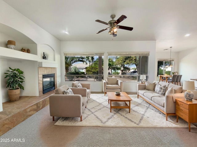 carpeted living room with a fireplace, built in features, and ceiling fan