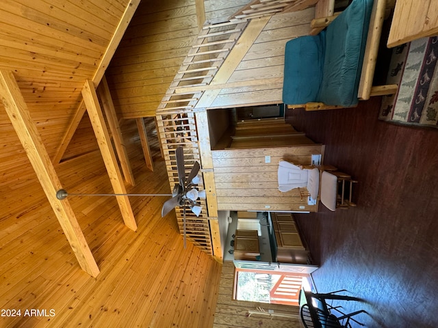 interior space featuring beamed ceiling, wooden walls, light brown cabinetry, and wood ceiling