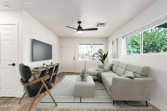 living room featuring hardwood / wood-style floors and ceiling fan