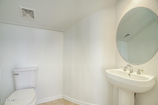 bathroom featuring tile patterned floors, visible vents, baseboards, and toilet