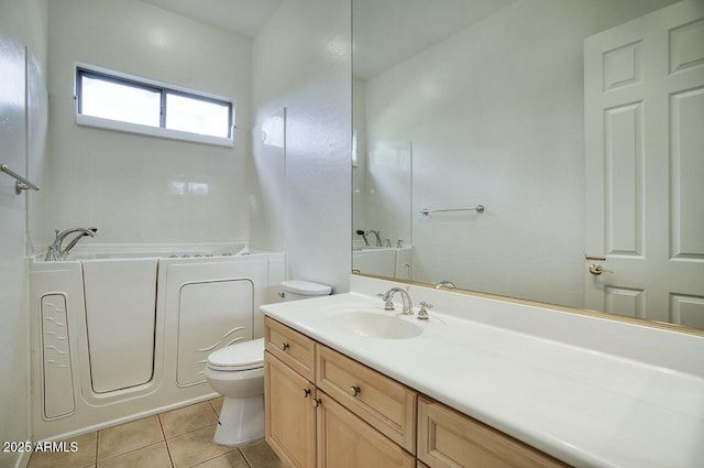 full bathroom featuring tile patterned flooring, vanity, toilet, and a bath