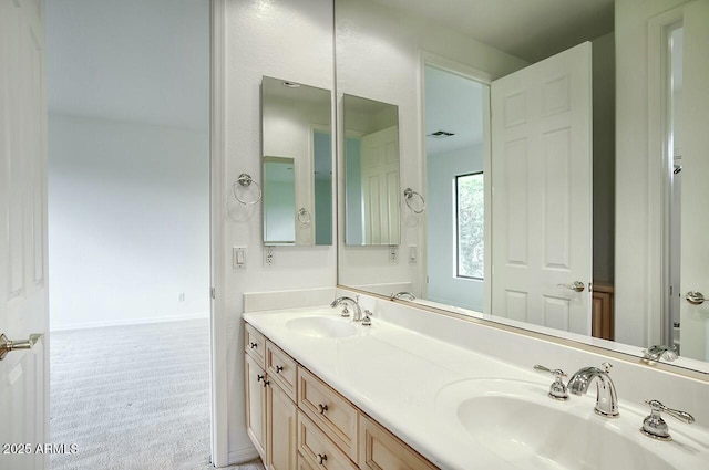 bathroom featuring a sink, visible vents, baseboards, and double vanity