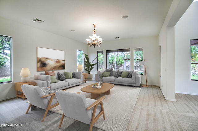 living area featuring a wealth of natural light, visible vents, baseboards, and an inviting chandelier