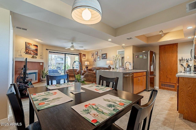 dining room featuring a tray ceiling, visible vents, and light tile patterned flooring