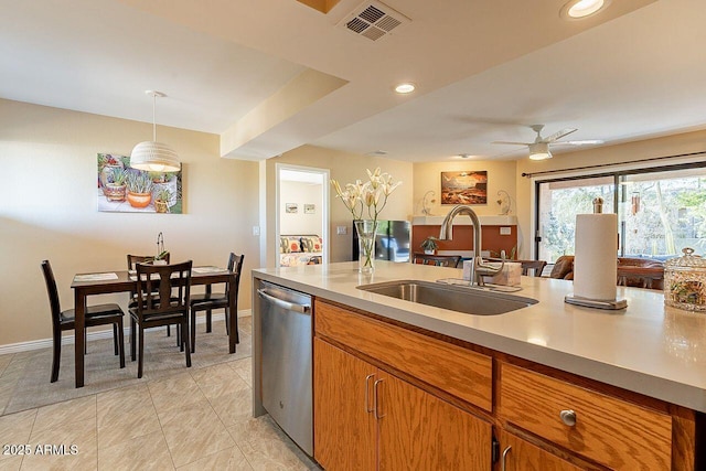 kitchen featuring brown cabinets, light countertops, dishwasher, and a sink