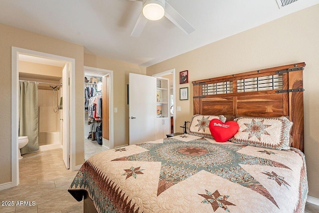 bedroom featuring baseboards, a ceiling fan, ensuite bath, a spacious closet, and a closet