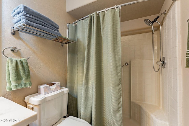 bathroom with a textured wall, a tile shower, and toilet