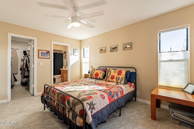 bedroom featuring connected bathroom, a spacious closet, baseboards, and ceiling fan