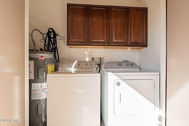 laundry area featuring washer and dryer, electric water heater, and cabinet space