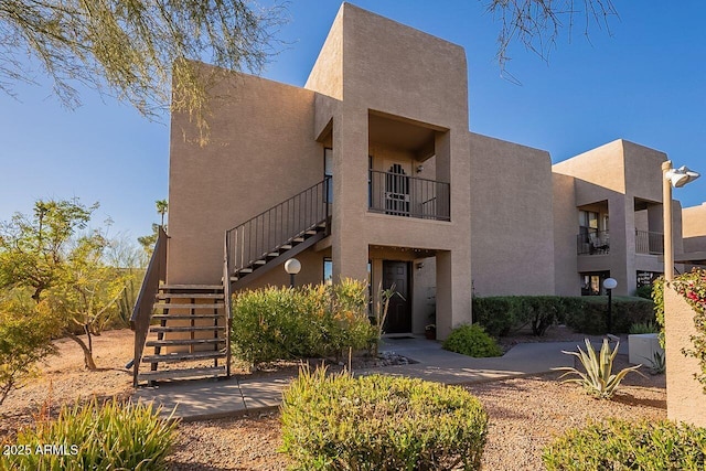 southwest-style home featuring stairs and stucco siding