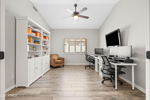 office area with light wood-style floors and vaulted ceiling