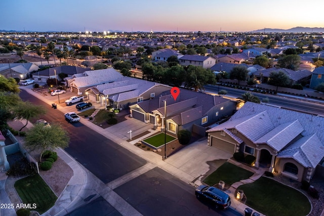 aerial view at dusk featuring a residential view and a mountain view