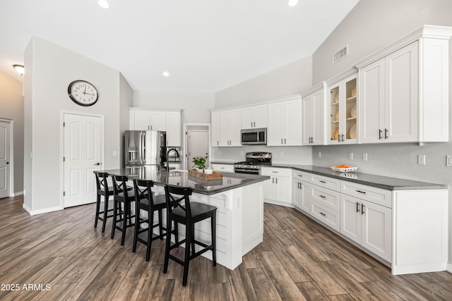 kitchen featuring visible vents, appliances with stainless steel finishes, a breakfast bar area, and white cabinets