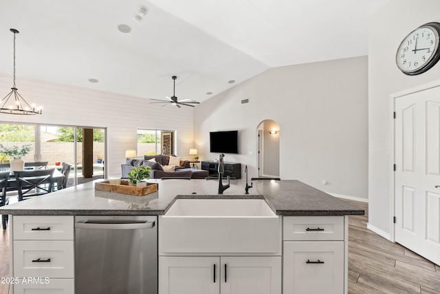 kitchen with white cabinets, a sink, ceiling fan with notable chandelier, lofted ceiling, and stainless steel dishwasher