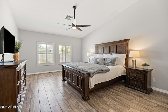 bedroom featuring baseboards, visible vents, wood finished floors, and lofted ceiling