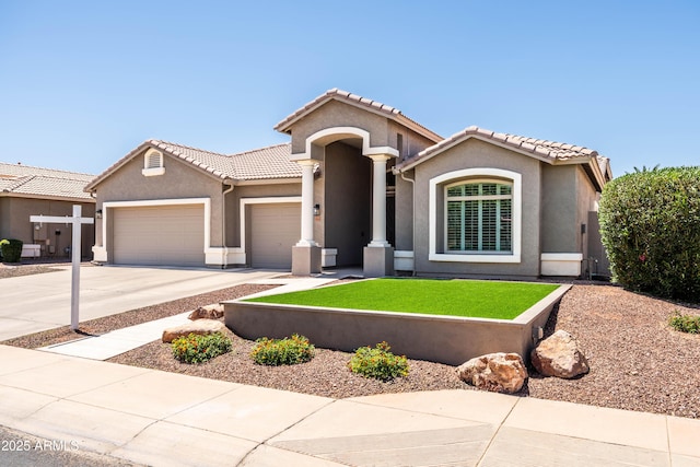 mediterranean / spanish-style house with a tiled roof, driveway, a front yard, a garage, and stucco siding