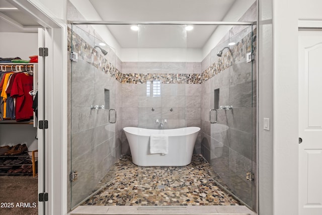 full bathroom featuring a soaking tub, a walk in closet, and a stall shower