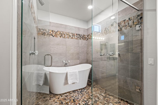 full bath with a soaking tub, tile walls, and a shower stall