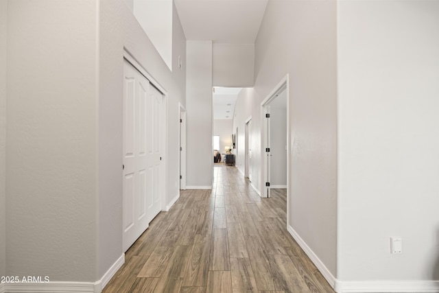 corridor featuring baseboards and wood finished floors